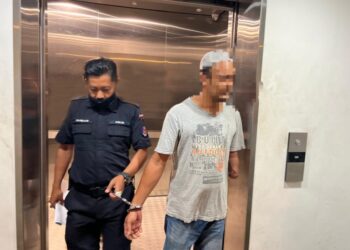 TERTUDUH (kiri) dibawa keluar dari Mahkamah Sesyen Kuala Terengganu, hari ini. - UTUSAN/TENGKU DANISH BAHRI TENGKU YUSOFF