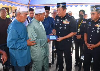 YAHAYA Othman (tiga, kanan) menyampaikan sumbangan kepada Ahmad Said Md. Piah (dua, kiri) bapa Muhammad Syafiq yang terkorban dalam serangan di Balai Polis Ulu Tiram, Johor Bahru di Taman Sri Mahkota Jaya di Kuantan, Pahang.