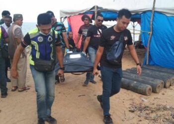 ANGGOTA polis mengusung mayat Muhammad Aiman Zambri yang ditemukan lemas di Pantai Geliga, Kemaman, petang semalam.