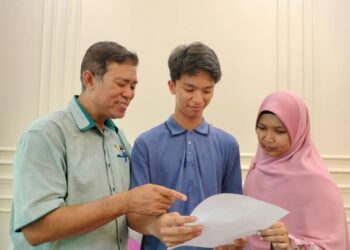 MUHAMMAD Adam Asyraff (tengah) bersama bapa, Mohd . Zaki Hassan dan ibunya, Haslena Harun melihat keputusan cemerlang SPM yang dicapainya di Chukai, Kemaman, hari ini. - UTUSAN/NIK NUR IZZATUL HAZWANI NIK ADNAN