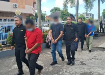 TIGA penjawat awam yang disyaki meminta dan menerima rasuah dibawa keluar dari Mahkamah Majistret Kemaman, hari ini. - UTUSAN/NIK NUR IZZATUL HAZWANI NIK ADNAN