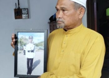 AHMAD SAID Md. Piah, 65, menunjukkan gambar Muhammad Shafiq yang segak ketika tamat menjalani latihan sebagai rekrut ketika ditemui di kediamannya di Taman Sri Mahkota Jaya di Kuantan, Pahang. - UTUSAN/ DIANA SURYA ABD WAHAB