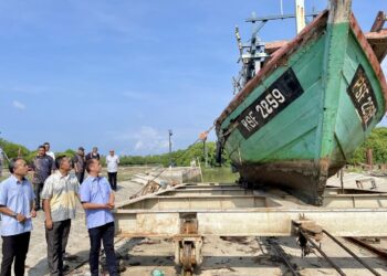 MUHAMMAD Faiz Fadzil (kanan) meninjau slipway milik PNK Kuala Kedah pada Majlis Rahmah Mesra Bersama Nelayan Kuala Kedah di Kampung Telok Layang, Kuala Kedah.