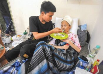 AKMAL FIKRI  Jaafar menyuap makanan kepada ibunya, Monisa Parmin yang terlantar akibat kanser paru-paru di rumah sewa mereka di Kampung Pasir, Tampoi, Johor Bahru.