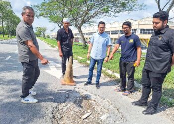 HARRISON Hassan (dua, kanan) bersama penduduk menunjukkan antara jalan berlubang di Taman Alam Jaya, Puncak Alam, Selangor. – UTUSAN/ISKANDAR SHAH MOHAMED
