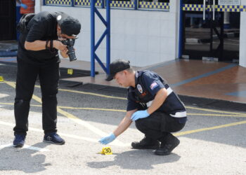 PASUKAN penyiasat memeriksa kelongsong peluru dalam kes balai polis diserang di Ulu Tiram, Johor Bahru, semalam. -UTUSAN/RAJA JAAFAR ALI 
Pemberita: Khairul/Sharkawi