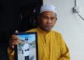 AHMAD SAID Md. Piah menunjukkan gambar Muhammad Shafiq yang segak ketika tamat menjalani latihan sebagai rekrut ketika ditemui di kediamannya di Taman Sri Mahkota Jaya di Kuantan, Pahang. - UTUSAN/ DIANA SURYA ABD WAHAB