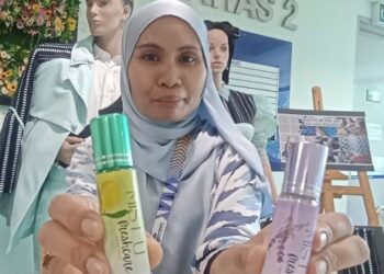 FARAH Nadia Murad menunjukkan minyak aroma terapi yang dihasilkan oleh pensyarah dan pelajar Kolej Komuniti Batu Gajah di Kampar, Perak, baru-baru ini. - UTUSAN/MEGAT LUTFI MEGAT RAHIM