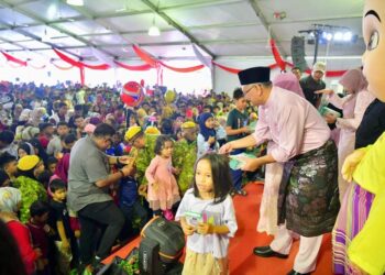 SHAMSUL Anuar Nasarah menyampaikan duit raya kepada kanak-kanak pada Majlis Mesra Rakyat sempena Jamuan Aidilfitri Lenggong hari ini. - UTUSAN