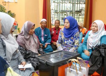 NORAINI Ahmad (dua dari kanan) menyantuni keluarga Allahyarham Konstabel Ahmad Azza Fahmi Azhar di Kampung Poh, Bidor hari ini. - UTUSAN/MUHAMAD NAZREEN SYAH MUSTHAFA