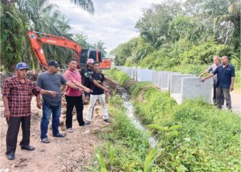 ZULKIFLI Ali (tiga, kiri) bersama beberapa penduduk kampung menunjukkan saluran air yang dibina untuk mengalirkan air kumbahan ke parit kecil di Lorong Datuk Ariss sebelum masuk ke parit besar di Kampung Bintang, Batu Pahat.