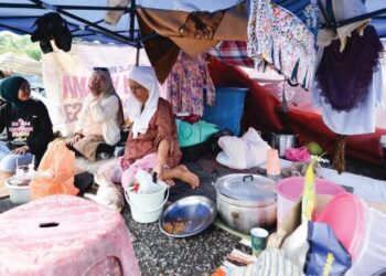 PENDUDUK, Rosiah Ismail (kanan) bersama keluarganya yang berteduh di bawah khemah sebagai tempat tinggal susulan kerja perobohan yang dilakukan di Kampung Sri Makmur, Taman Sri Gombak, kelmarin. 
 – UTUSAN/SYAKIR RADIN