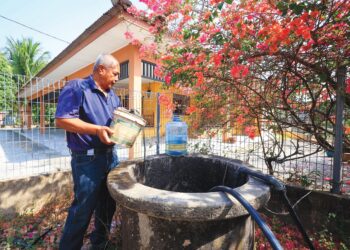 ISMAIL Osman mengambil air dari perigi merdeka untuk kegunaan harian sepanjang musim kemarau 
di  Kampung Padang Kala, Kota Bharu, Kelantan. – UTUSAN/KAMARUL BISMI KAMARUZAMAN