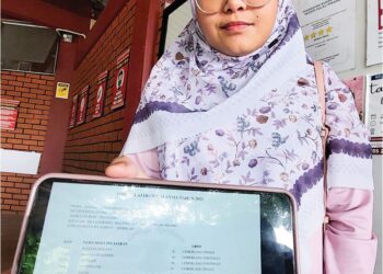 AISYAH Mohd. Rosdi menunjukkan keputusan SPM 2023 yang dimuat turun ke dalam telefon miliknya.