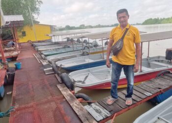 BUDIMAN Kaidir menunjukkan bot sewa untuk kaki pancing dan pelancong yang mahu menyusuri Sungai Perak di Teluk Intan. 
– UTUSAN/AIN SAFRE BIDIN