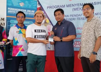 BADRUL Hisham Alias (dua, kanan) menyampaikan MyKad kepada penduduk melalui Program Mekar di Pulau Perhentian, Besut, semalam. - UTUSAN/WAN ZURATIKAH IFFAH WAN ZULKIFLI
