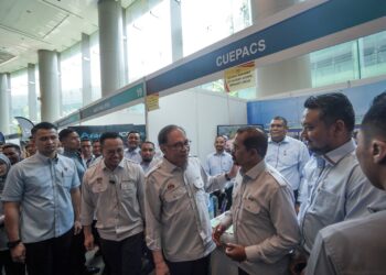 ADNAN Mat berbual dengan Anwar Ibrahim pada sambutan Hari Pekerja 2024 di Putrajaya.- UTUSAN/FAISOL MUSTAFA