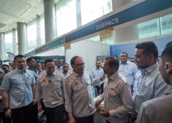 ADNAN Mat berbual dengan Anwar Ibrahim pada sambutan Hari Pekerja 2024 di Putrajaya.- UTUSAN/FAISOL MUSTAFA