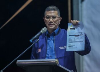 MOHAMED Azmin Ali menunjukkan notis permakluman cukai pintu baharu yang dikeluarkan oleh MPAJ di Ceramah Perdana PN di Pekan Batang Kali, malam tadi. - UTUSAN/M. FIRDAUS M. JOHARI.