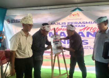 NIK Nazmi Nik Ahmad (dua dari kanan) menyampaikan cenderamata kepada wakil komuniti pada Majlis Perasmian Program Kampung Angkat Madani di Kampung Aril, Melor, Kota Bharu, Kelantan. UTUSAN/ROSMIZAN RESDI