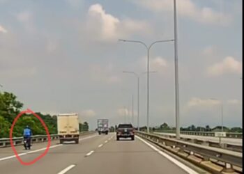 TANGKAP layar yang diambil daripada satu rakaman video tular menunjukkan mangsa (dalam bulatan merah) cuba memotong sebuah lori sebelum bergesel dan jatuh tergolek selepas merempuh pembahagi jalan di BKE, Pulau Pinang