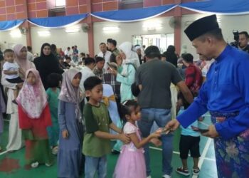 MOHD. Yusri Hassan Basri memberikan duit raya kepada kanak-kanak pada majlis hari raya Aidilfitri di Langkap dekat Pasir Salak semalam.