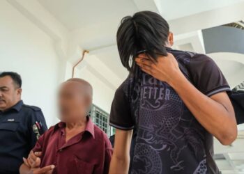 TERTUDUH (kanan) diiring keluar anggota polis selepas dihadapkan ke Mahkamah Sesyen, Alor Gajah, Melaka atas dua pertuduhan merogol anak saudara tirinya. - UTUSAN/SYAFEEQ AHMAD