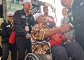 SALAH seorang jemaah haji yang berkerusi roda menerima sambutan daripada para petugas Tabung Haji.