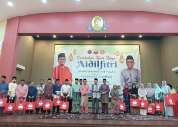 Hasni (tengah) bergambar bersama penerima bantuan haji dalam Rumah Terbuka UMNO Pulai di Kompleks Tan Sri Mohamed Rahmat, Tampoi, Johor Bahru