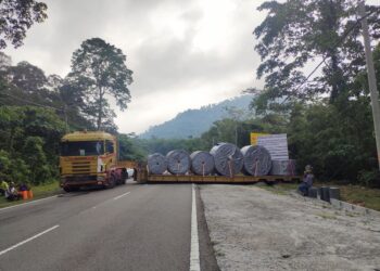 SEBUAH lori yang membawa muatan berat berupa lima gelungan getah padu melintang di tengah jalan dalam kejadian di di kilometer empat Jalan Bukit Miku-Inas, Rembau petang tadi.-UTUSAN/NOR AINNA HAMZAH.