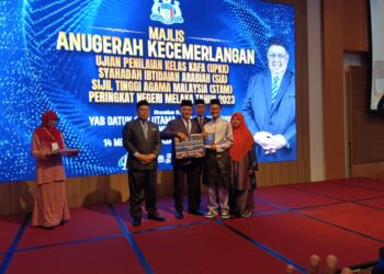 RAHMAD Mariman (tengah) menyampaikan anugerah pada Majlis Anugerah Kecemerlangan Pelajar UPKK, SIA dan STAM Peringkat Negeri di sebuah hotel di Banda Hilir, Melaka.