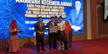 RAHMAD Mariman (tengah) menyampaikan anugerah pada Majlis Anugerah Kecemerlangan Pelajar UPKK, SIA dan STAM Peringkat Negeri di sebuah hotel di Banda Hilir, Melaka.