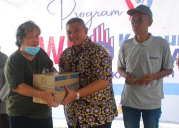 RAIS Yasin menyampaikan kit makanan dan wang tunai kepada seorang penerima pada Program Jalinan Insan Wahana Aspirasi (Jiwa) Komuniti Madani Krubong di Surau Al-Falah, Krubong Jaya, Melaka, hari ini. - UTUSAN/AMRAN MULUP