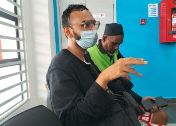 RASHID (kiri) menceritakan kembali kejadian kebakaran yang berlaku di rumah kedai dua tingkat yang mengorbankan ibu, abang dan adik perempuannya di Balik Pulau, Pulau Pinang
