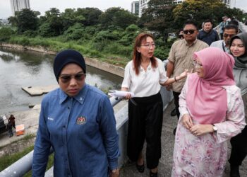MENTERI di Jabatan Perdana Menteri (Wilayah Persekutuan), Dr. Zaliha Mustafa (kanan) mendengar sesuatu yang diperkatakan Teresa Kok ketika meninjau tapak kolam takungan banjir Kampung Bohol.