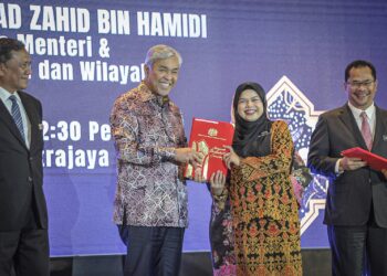 AHMAD Zahid Hamidi menyampaikan Anugerah Perkhidmatan Cemerlang kepada Pegawai Penerangan S41, Asilla Suraya Fitriah Zolkifli pada Majlis Anugerah Perkhidmatan Cemerlang (APC) KKDW di Putrajaya. - UTUSAN/FAIZ ALIF ZUBIR