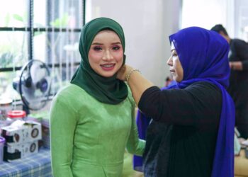 ROZITA Hamzah (kanan) tekun menyiapkan seorang pengantin di Jerantut, Pahang. – UTUSAN/HARIS FADILAH