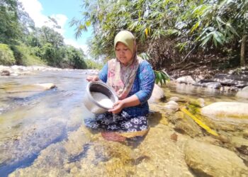 CHE Norasmariza Che Rezani mencuci beras di Sungai Kachong selepas air telaga kering akibat cuaca panas di rumahnya di Kampung Baru, Lata Tembakah, Besut. - UTUSAN/
WAN ZURATIKAH IFFAH WAN ZULKIFLI