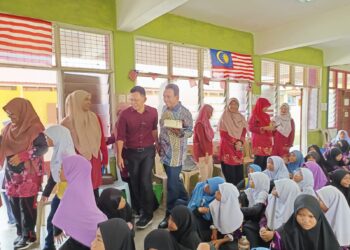 MOHD. Isam Mohd. Isa meneruskan tradisi menghadiahkan kek ke semua sekolah di parlimen berkenaan sempena sambutan hari guru di Tampin hari ini.-UTUSAN/NOR AINNA HAMZAH.