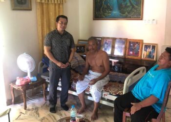 KAMARUL Azman Khamis (kiri) melawat seorang pesakit kanser di Kampung Perik, Kuala Nerang hari ini.-UTUSAN