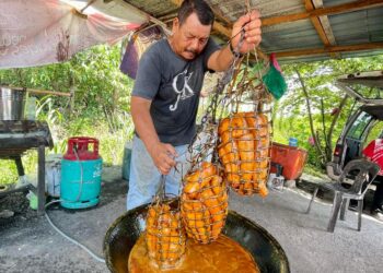 Zainal Abidin Daud menunjukkan ubi telampong yang hampir masak setelah lapan jam direbus bersama air tebu di gerainya di Kampung Tok Kesop, Jitra di Kubang Pasu.