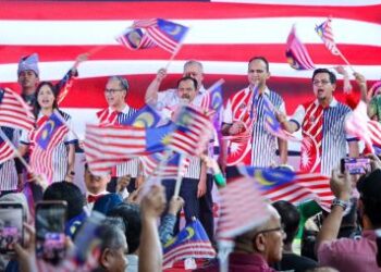 FAHMI Fadzil bersama Teo Nie Ching mengibar Jalur Gemilang ketika pelancaran Ekspresi Bulan Kebangsaan 2024 di Stesen Sentral Kuala Lumpur, semalam. - UTUSAN/SADDAM YUSOFF