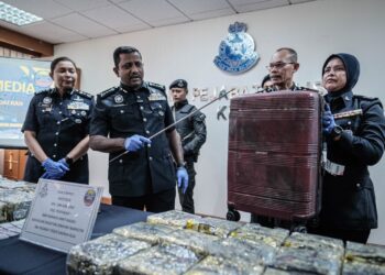 HUSSEIN Omar Khan menunjukkan bagasi bagasi yang dibawa suspek mengandungi dadah dalam sidang akhbar di IPD KLIA. - UTUSAN/FAIZ ALIF ZUBIR