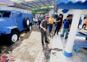 RAZARUDIN Husain melihat senjata yang digunakan oleh suspek untuk menembak anggota polis dalam kejadian yang mengorbankan dua anggota polis di Balai Polis Ulu Tiram Johor Bahru. - UTUSAN/RAJA JAAFAR ALI