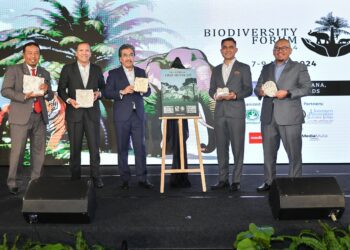 Johari Abdul Ghani (tiga dari kiri)  dan Mad Zaidi Mohd. Karli (dua dari kiri) menunjukkan Buku Panduan Pengecaman Tapak Hidupan Liar yang menjadi panduan dalam menguruskan hidupan liar di ladang pada Forum Biodiversiti 2024 di Genting Highlands, semalam.