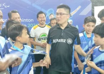 WONG Kah Woh bersama pelajar yang menyertai Kejohanan Badminton Remaja Allianz  di Taiping hari ini. - UTUSAN/WAT KAMAL ABAS