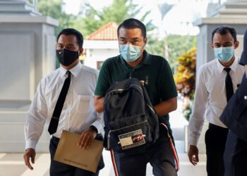 YUSMADI Yusof (tengah) tiba di Mahkamah Sesyen Kuala Lumpur bagi menghadapi pertuduhan menipu pelaburan dalam projek pembekalan bahan-bahan keperluan Petronas. – UTUSAN/SHIDDIEQIIN ZON