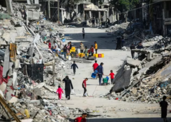 PENDUDUK Palestin berjalan di sepanjang jalan yang musnah di Khan Younis, selatan Gaza. -AFP