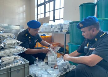 ANGGOTA penguat kuasa KPDN Perak menyita produk pau dan kopi sebuah kilang yang menggunakan logo halal tamat tempoh di Tanjung Malim semalam. - UTUSAN/IHSAN KPDN PERAK