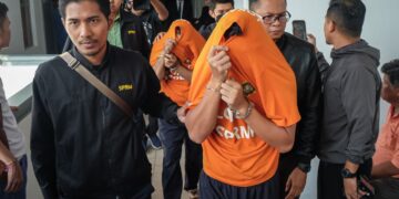 KEDUA-DUA tertuduh tiba di Kompleks Mahkamah Ayer Keroh, Melaka dengan memakai pakaian lokap SPRM berwarna jingga. - UTUSAN/SYAFEEQ AHMAD